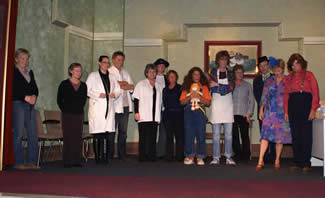 De voltallige groep vlnr; Tiny Bruschke(rekwisieten), Ciska Lieferink(souffleuse), Martine v.d. Putten(Saskia de Ruyter), John Groot(Erwin Kokkernoot), Ria Terluin(Karin Rietveld), Bart Winder(Frank Mees), Marjoka Groot(grimeur), Tineke Groot(Annelies van Acht), Mark Admiraal(Sven de Braak), Stina Hof(regisseur), Peter de Groot(Meneer van Ruwenhove), Mary Winder(Magda van Veenwijk), Jan Bloedjes(Fred het Gedrocht). Abner Verschuur(Baron Eugene van Brachtenstijn - Haeverdoor) ontbreekt.